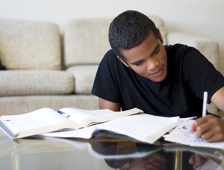 image of student sitting at table taking notes