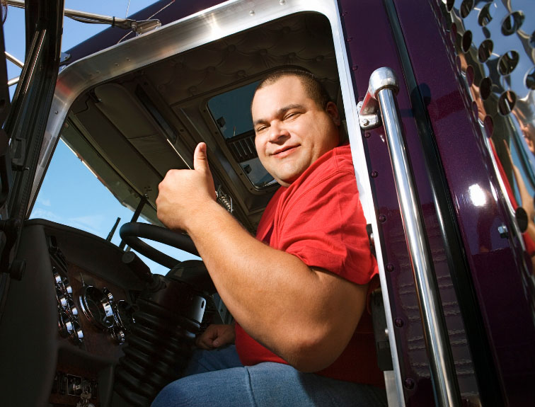 image of Semi driver sitting in driver seat, giving a thumbs up.