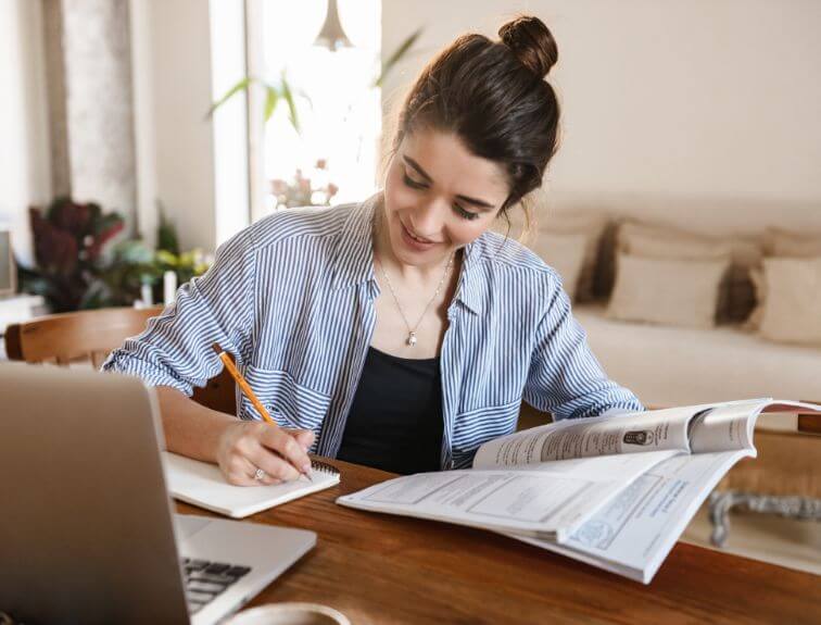 Image of person studying at desk with books and computer