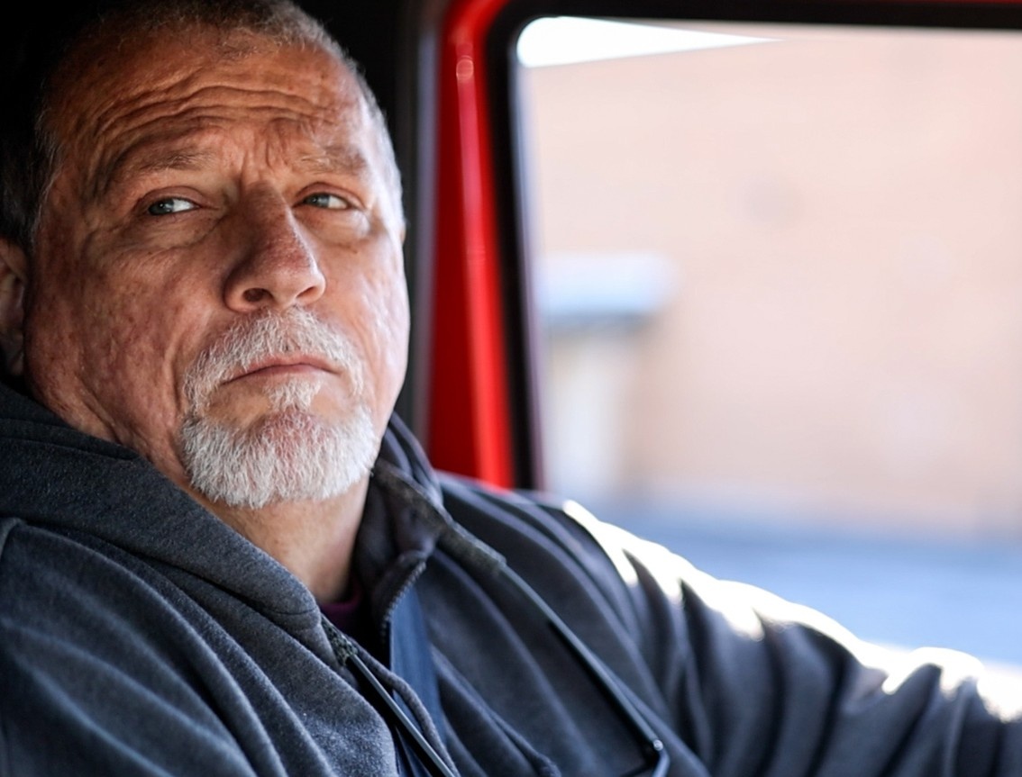 CDL truck driver instructor seated in the cab of a semi-truck