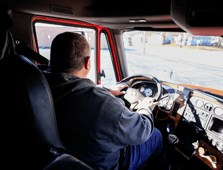 Backseat view of semi truck driver steering semi truck