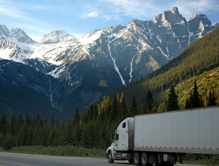image of white truck driving through the mountains