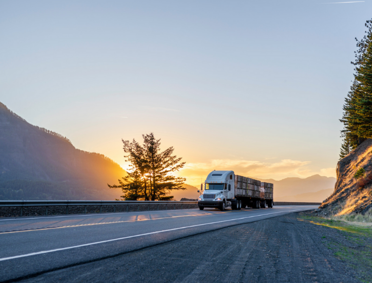 image of semi driving in front of sunset