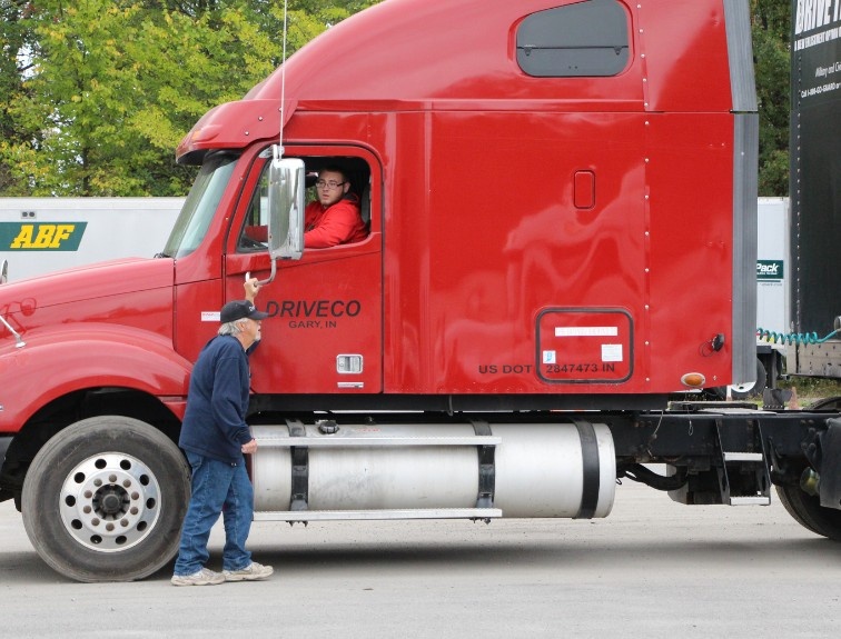 Instructor leading student driving a semi truck